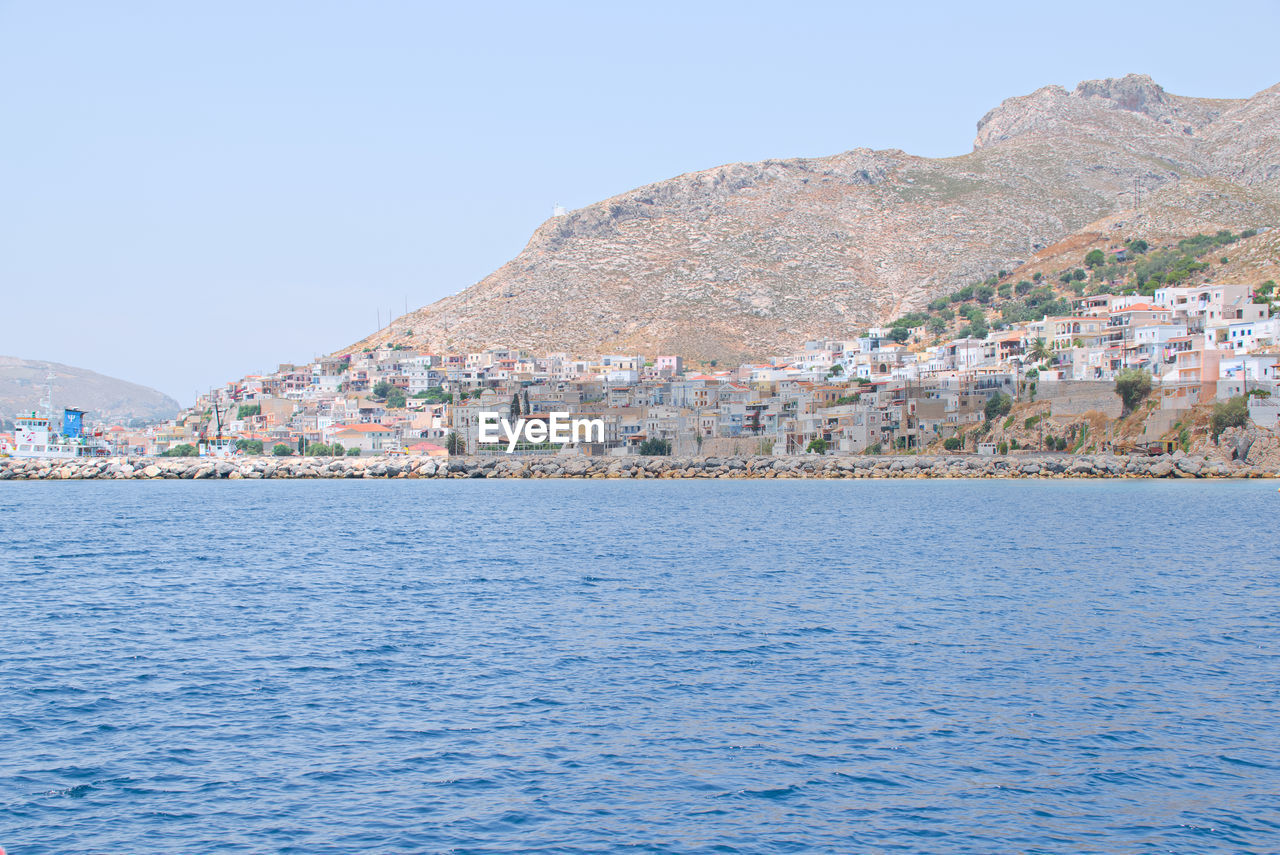 Scenic view of sea by town against sky