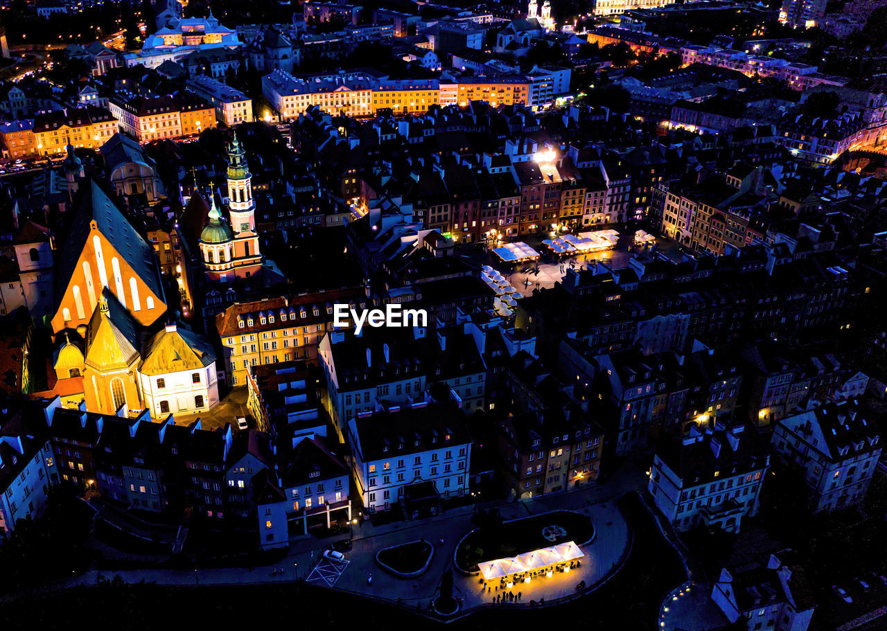 Cityscape with high angle above aerial view of historic architecture old town market square at night