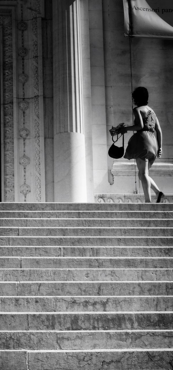 LOW ANGLE VIEW OF WOMAN WALKING UP STAIRS
