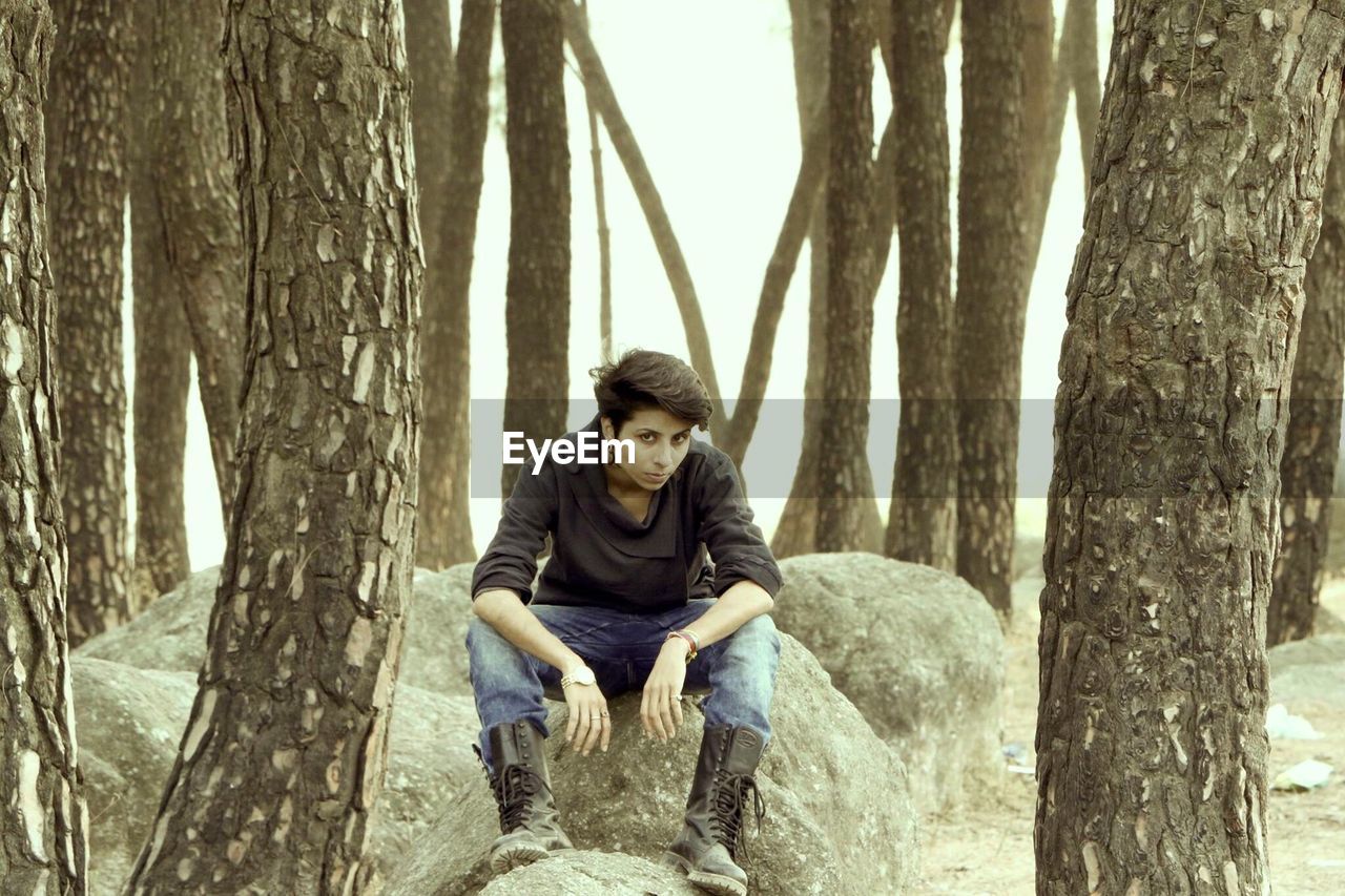 Full length of woman sitting in forest