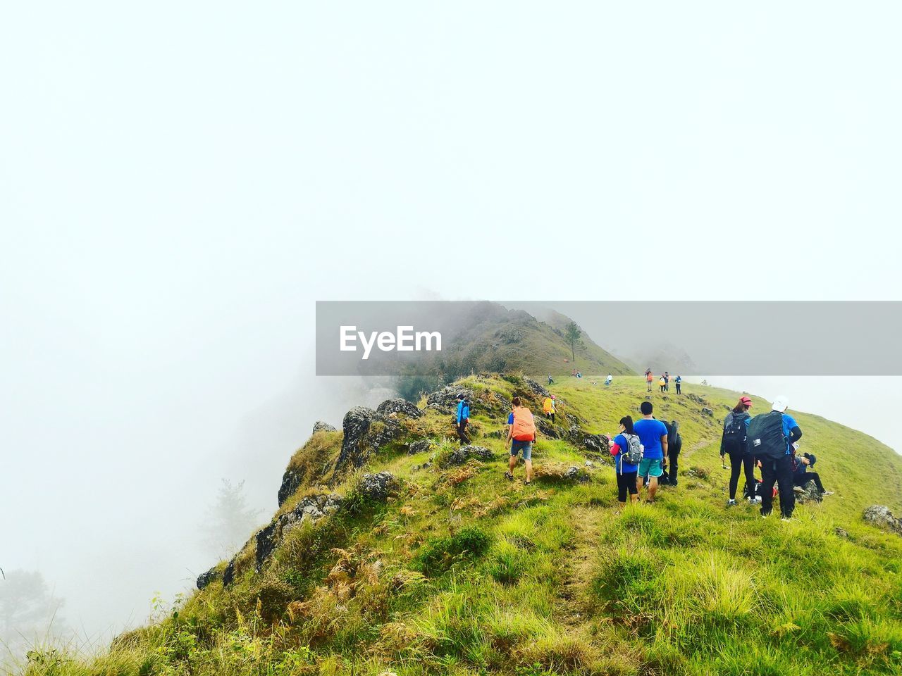 People walking on mountain during foggy weather