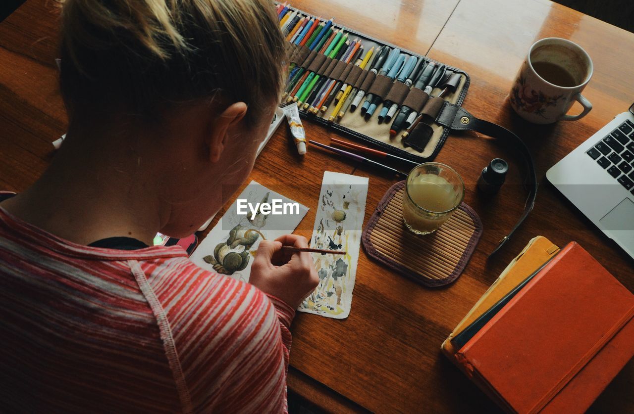 High angle view of woman painting easter bunny