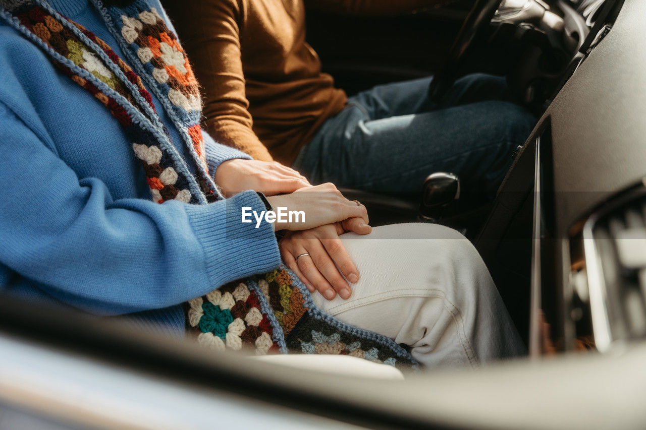 Couple in car holding hands, finding comfort in each other