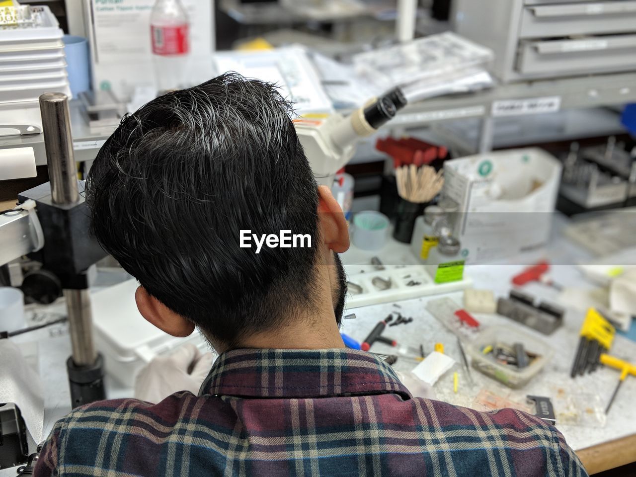 Rear view of man sitting in workshop