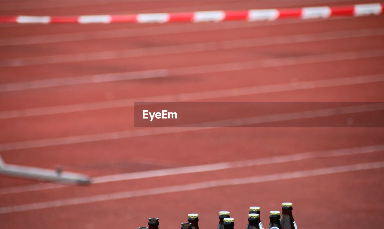 Full frame shot of bottles against running track 