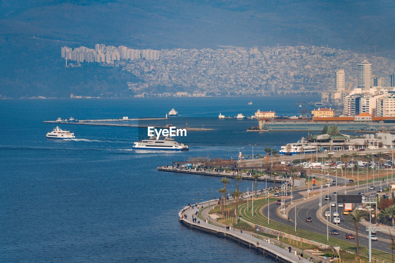 High angle view of cityscape by sea against sky