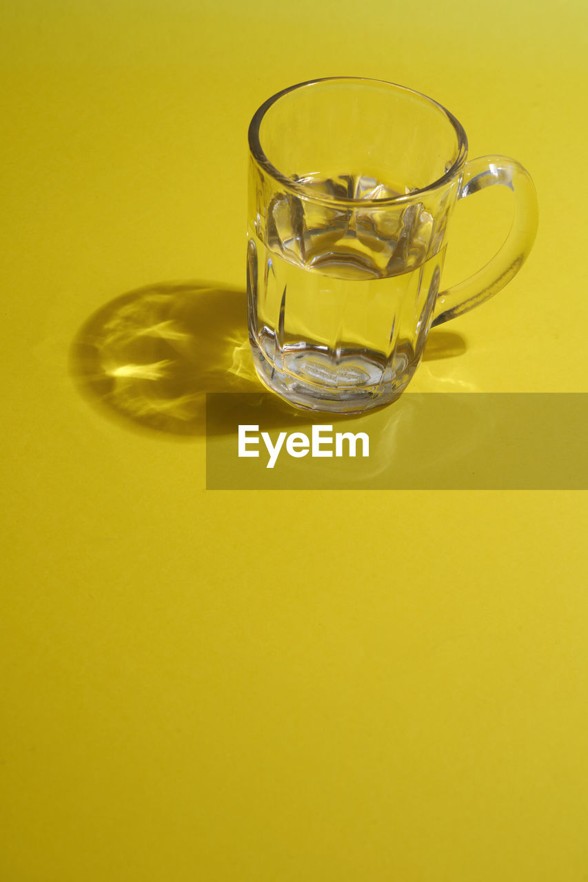 Glass of water on the yellow background