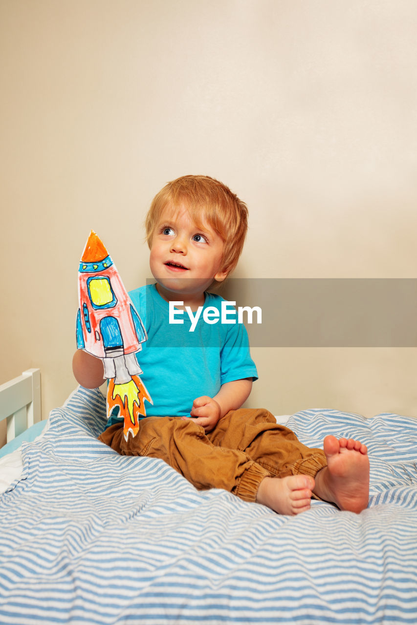 portrait of cute baby boy lying on bed