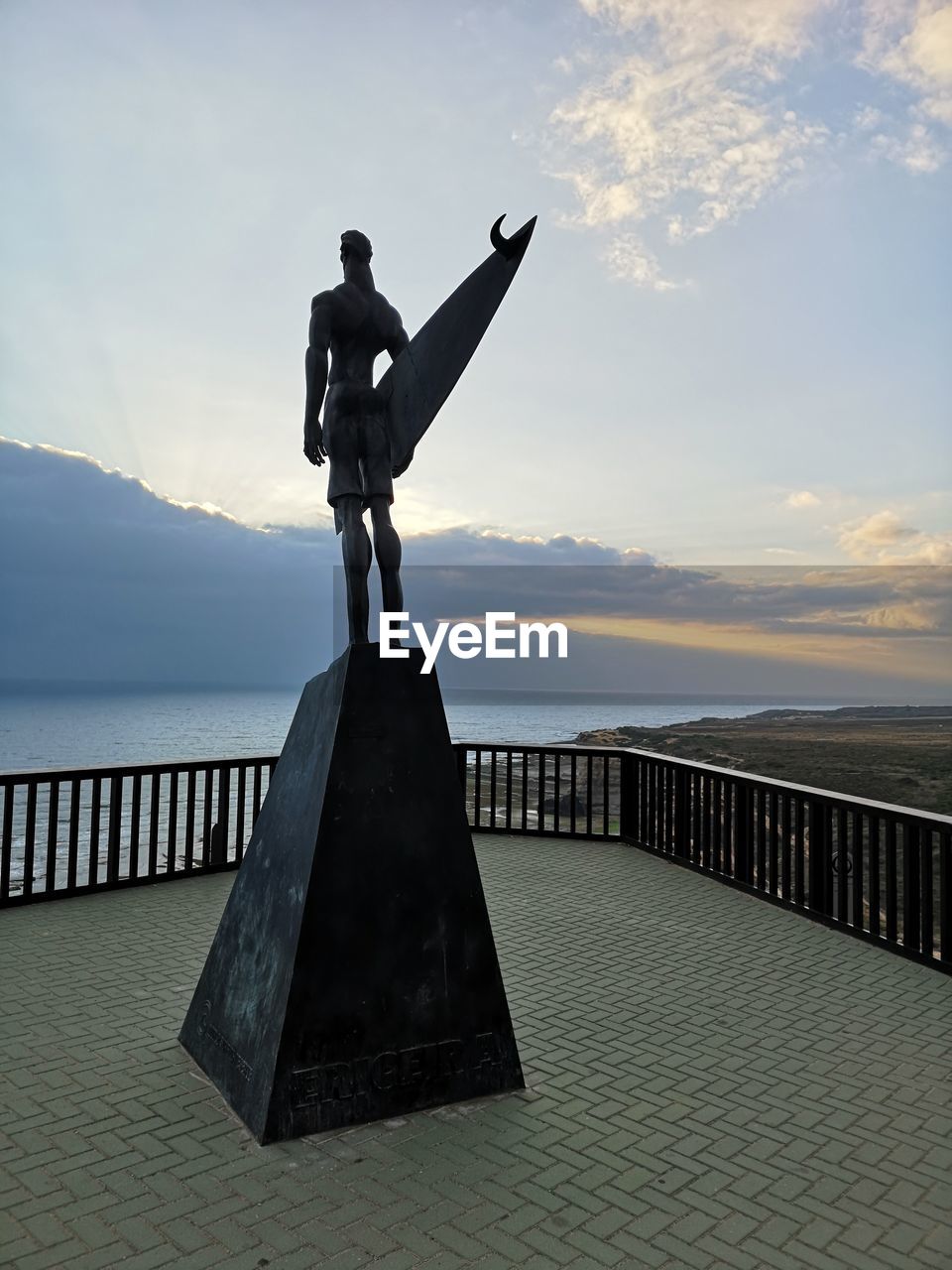 MAN STANDING ON RAILING AGAINST SEA