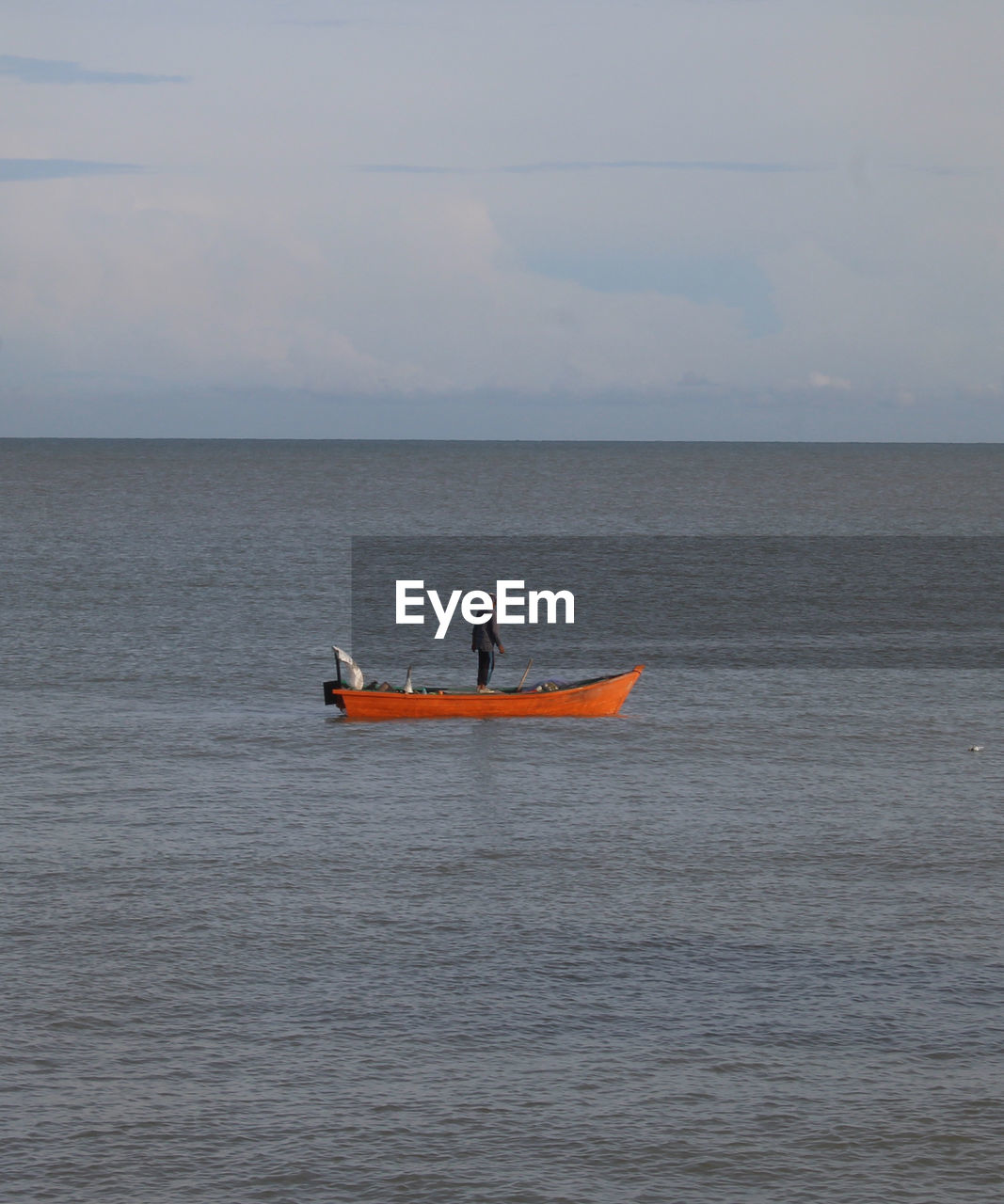 Man kayaking on sea against sky