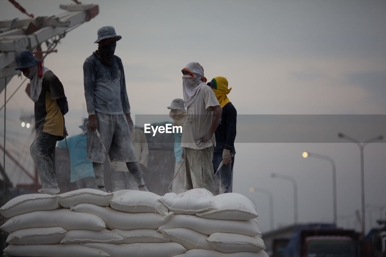 Men unloading cement bags at dockyard