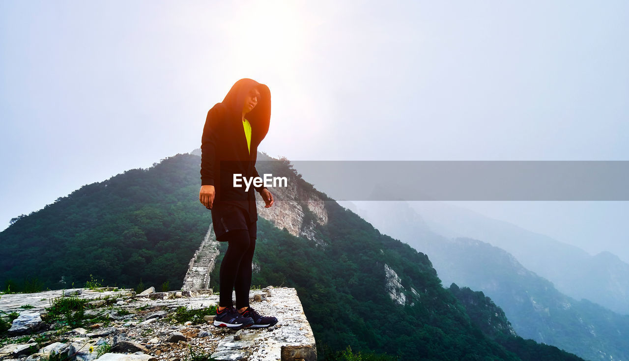 Full length of man standing on mountain against sky