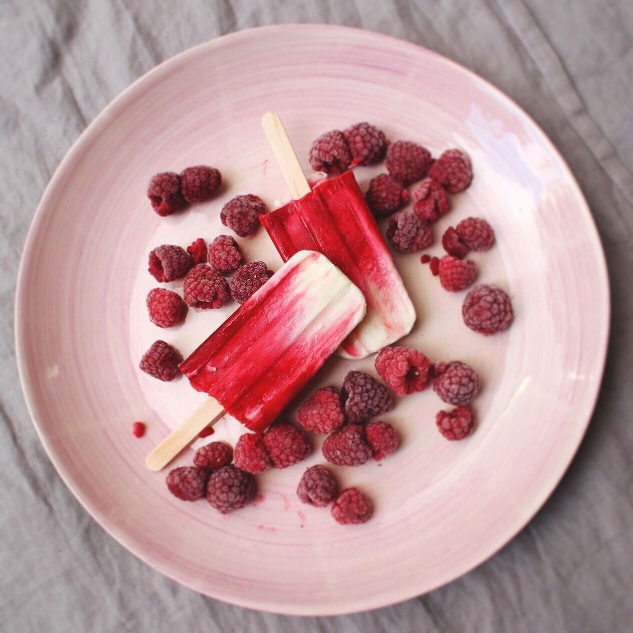 Homemade raspberry popsicles on a plate