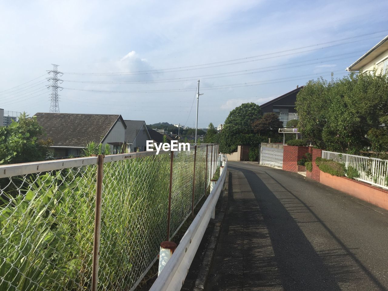 Walkway amidst houses and buildings against sky