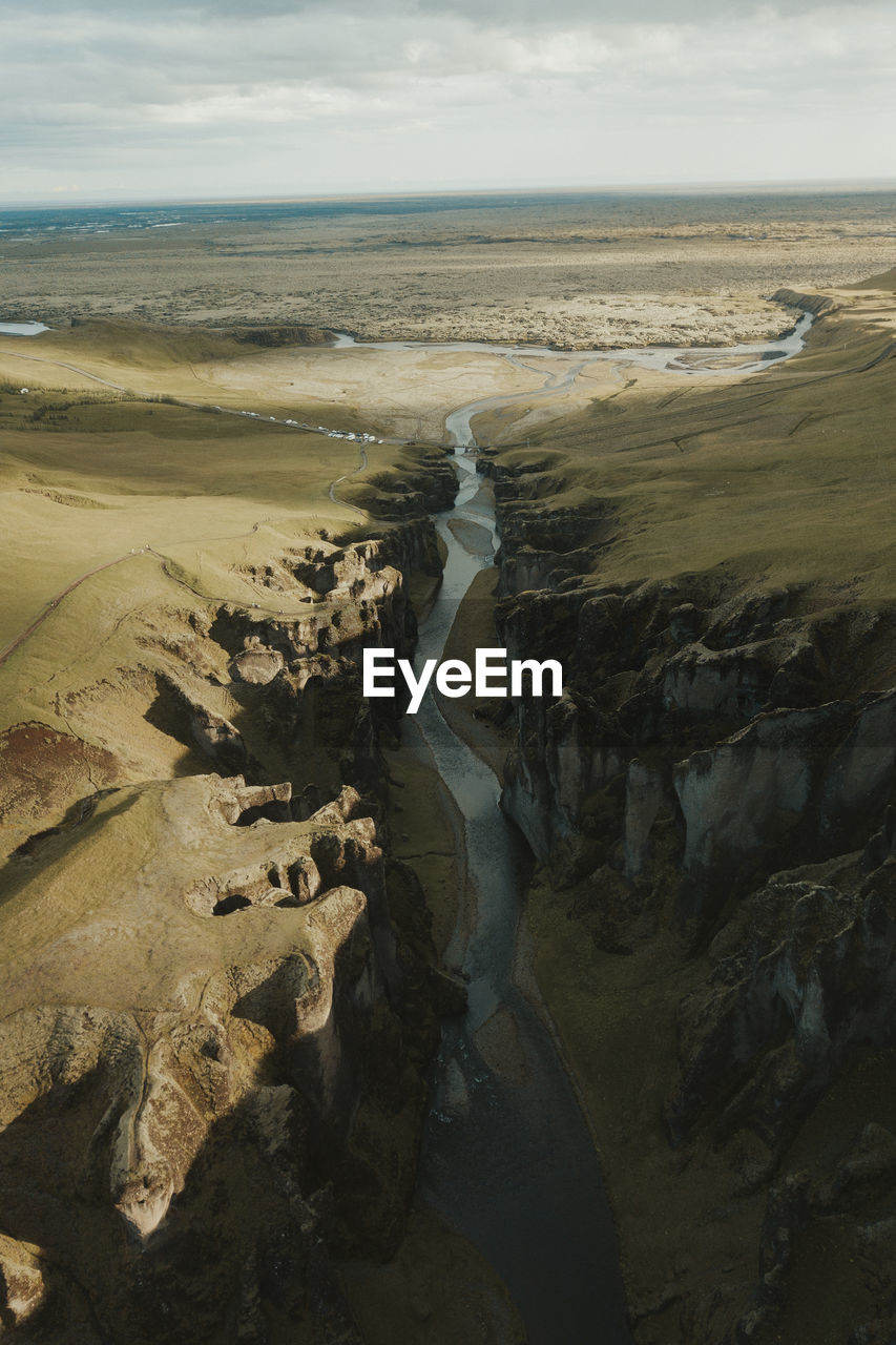 HIGH ANGLE VIEW OF SHORE AND SEA AGAINST SKY