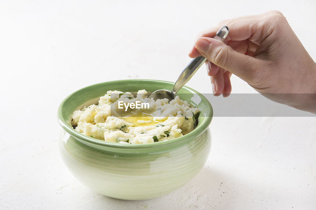 CROPPED IMAGE OF PERSON HOLDING BOWL OF TABLE