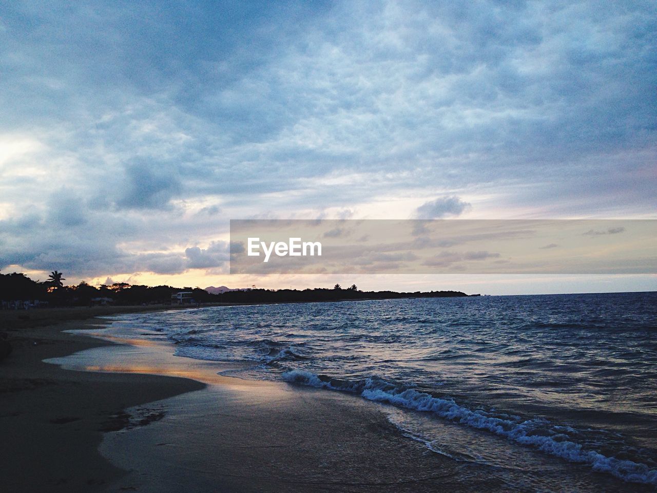 Scenic view of calm sea against cloudy sky