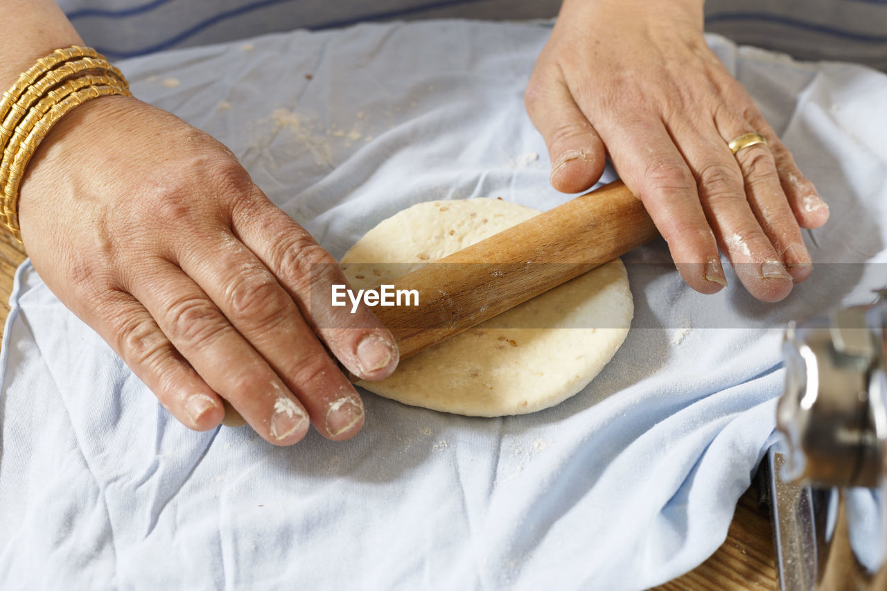 Cropped image of woman preparing dough at home