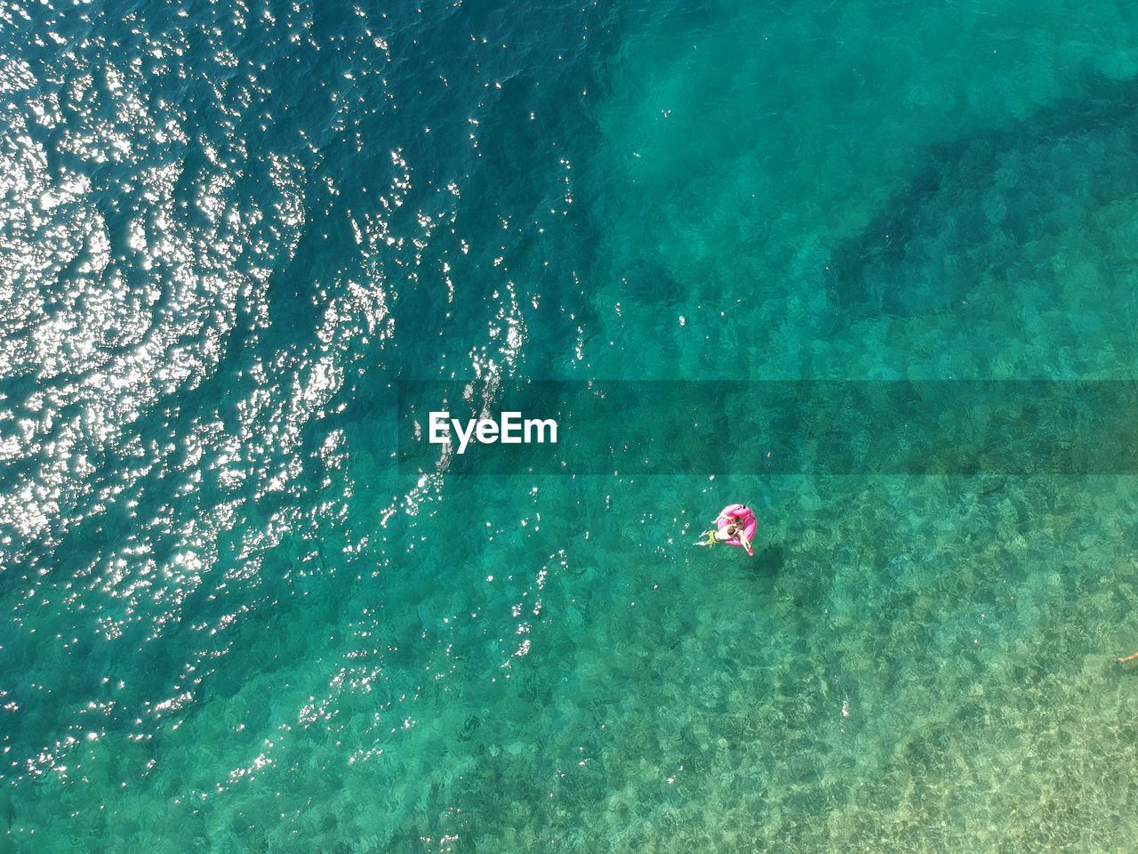 HIGH ANGLE VIEW OF GIRL SWIMMING IN SEA