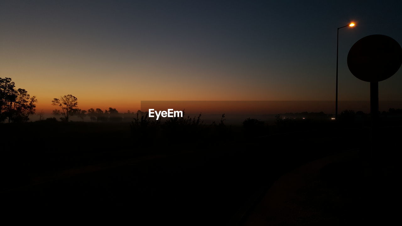 Silhouette landscape against sunset sky