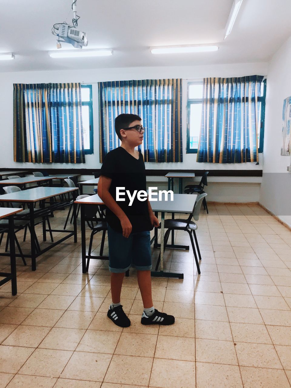 Full length side view of boy standing in classroom