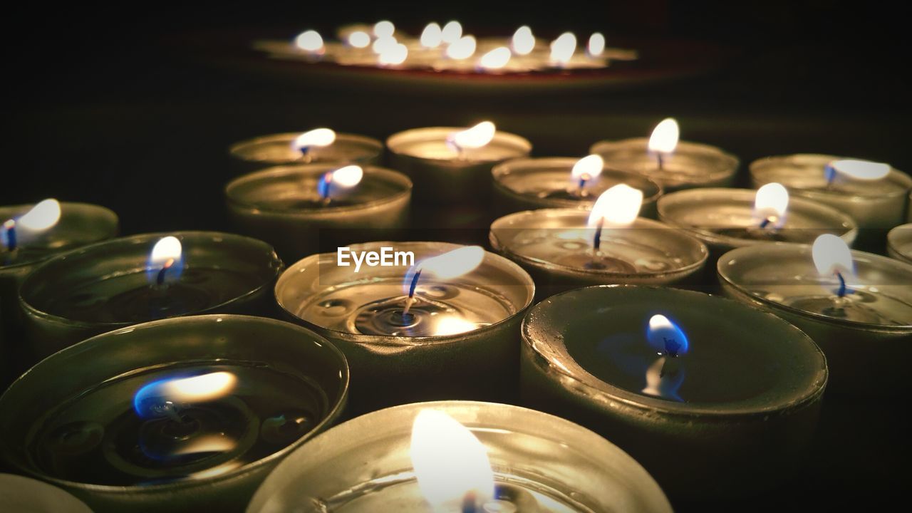 Close-up of lit candle in dark room