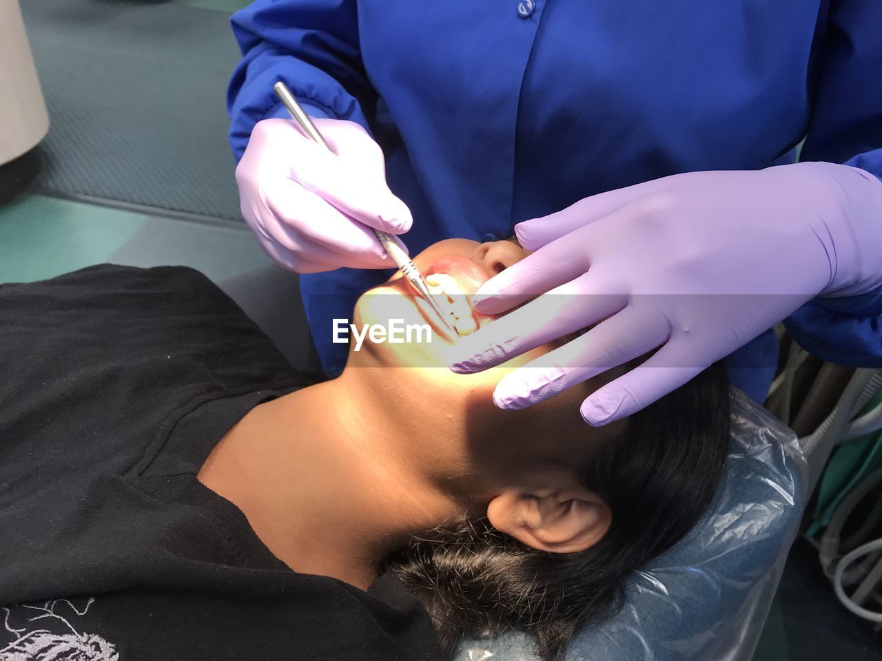 Midsection of dentist examining girl