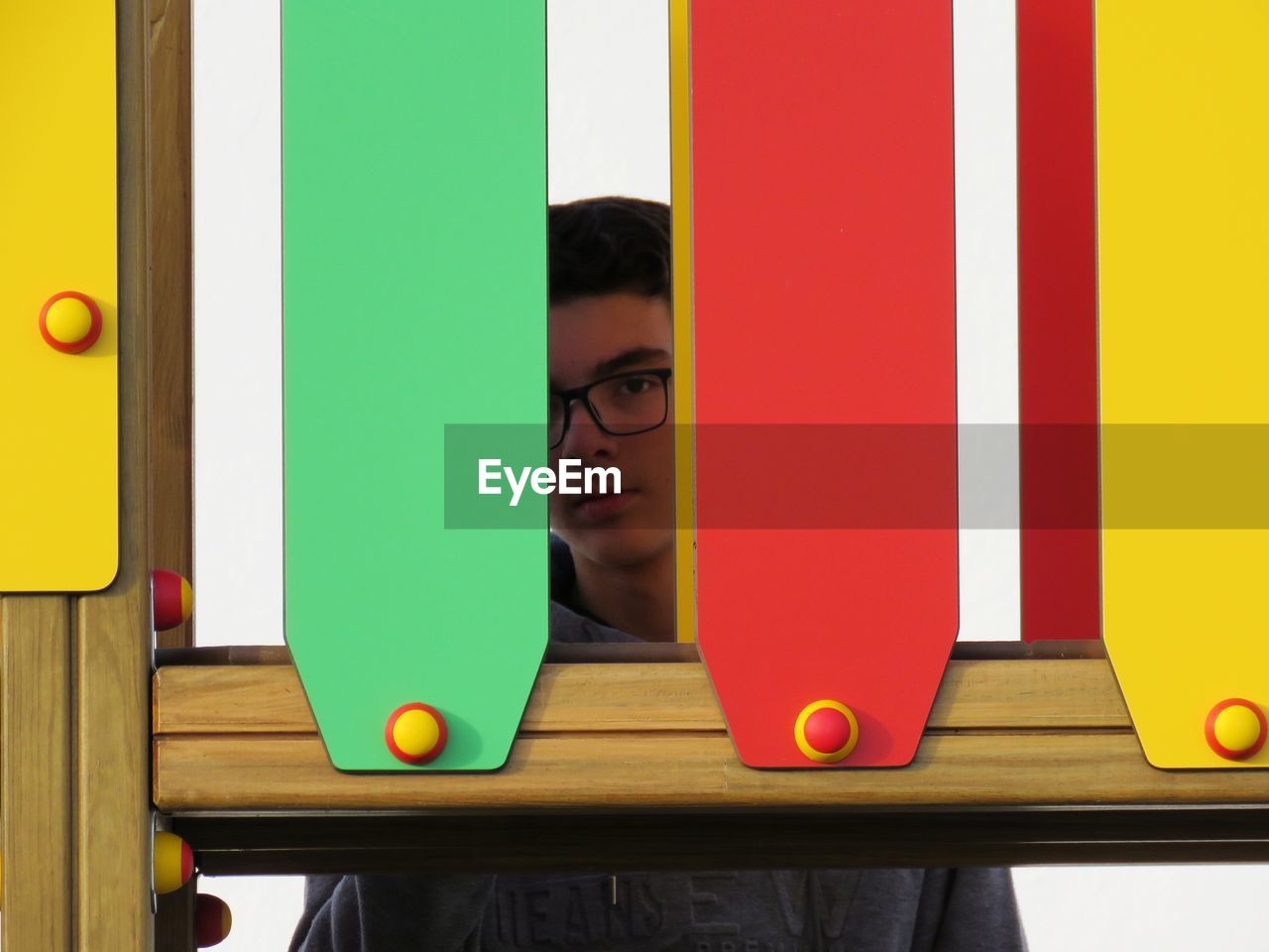 Portrait of boy seen through colorful play equipment