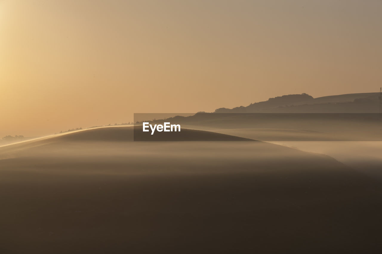 Scenic view silhouette mountains against sky during sunrise