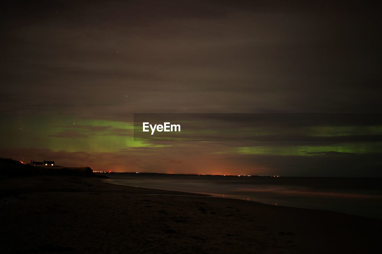 SCENIC VIEW OF BEACH AGAINST SKY AT SUNSET