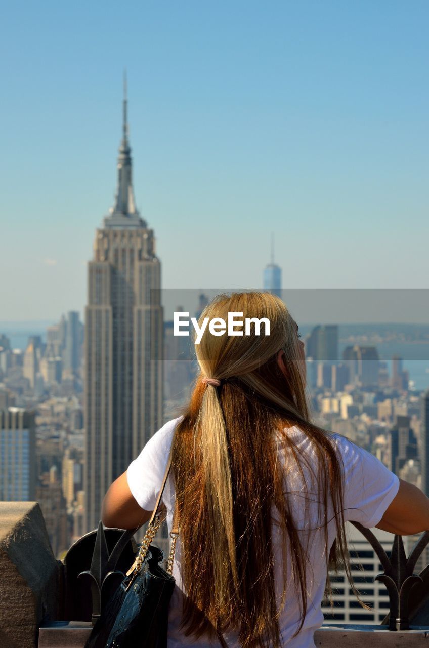 Woman on skyscraper looking at cityscape