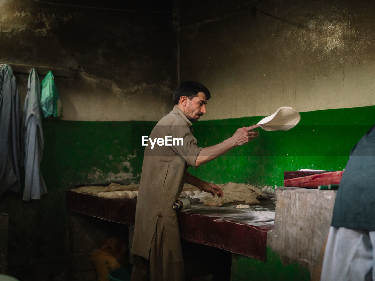 Man preparing chapatti in kitchen