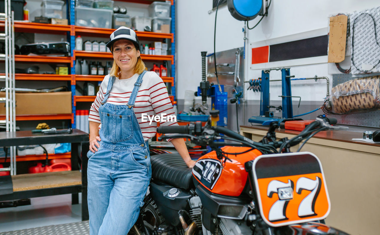 Mechanic woman standing on motorcycle factory
