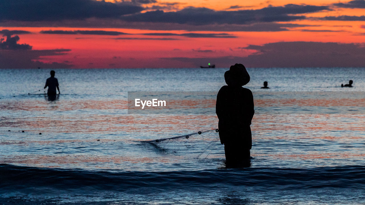 A fisherman is fishing at sunset on koh rong, cambodia