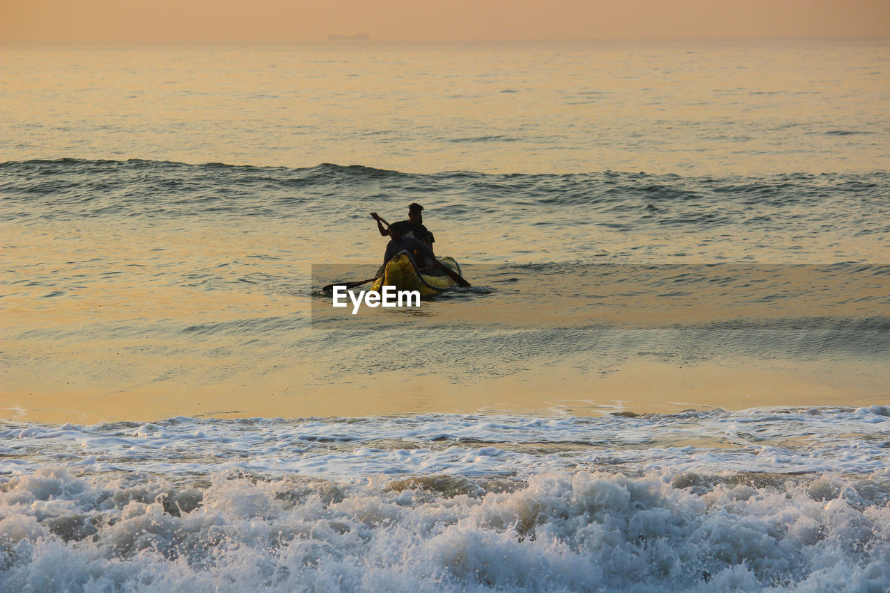 People on boat in sea during sunset