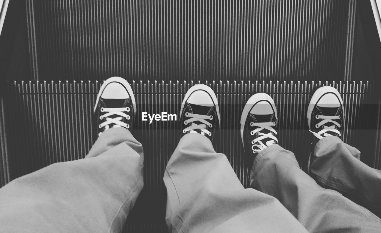 Low section of people standing on escalator