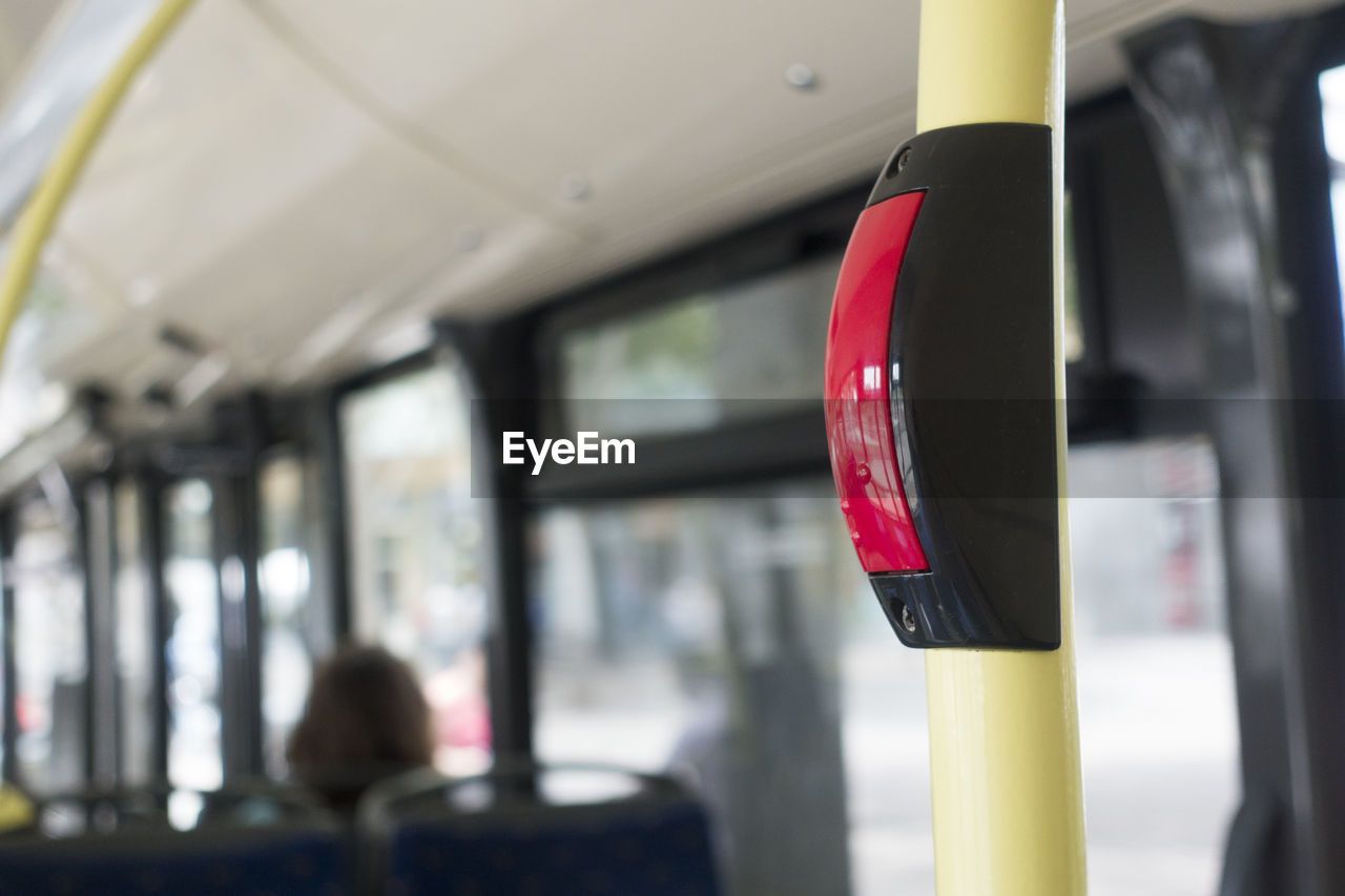 Close-up of red push button on pole in bus