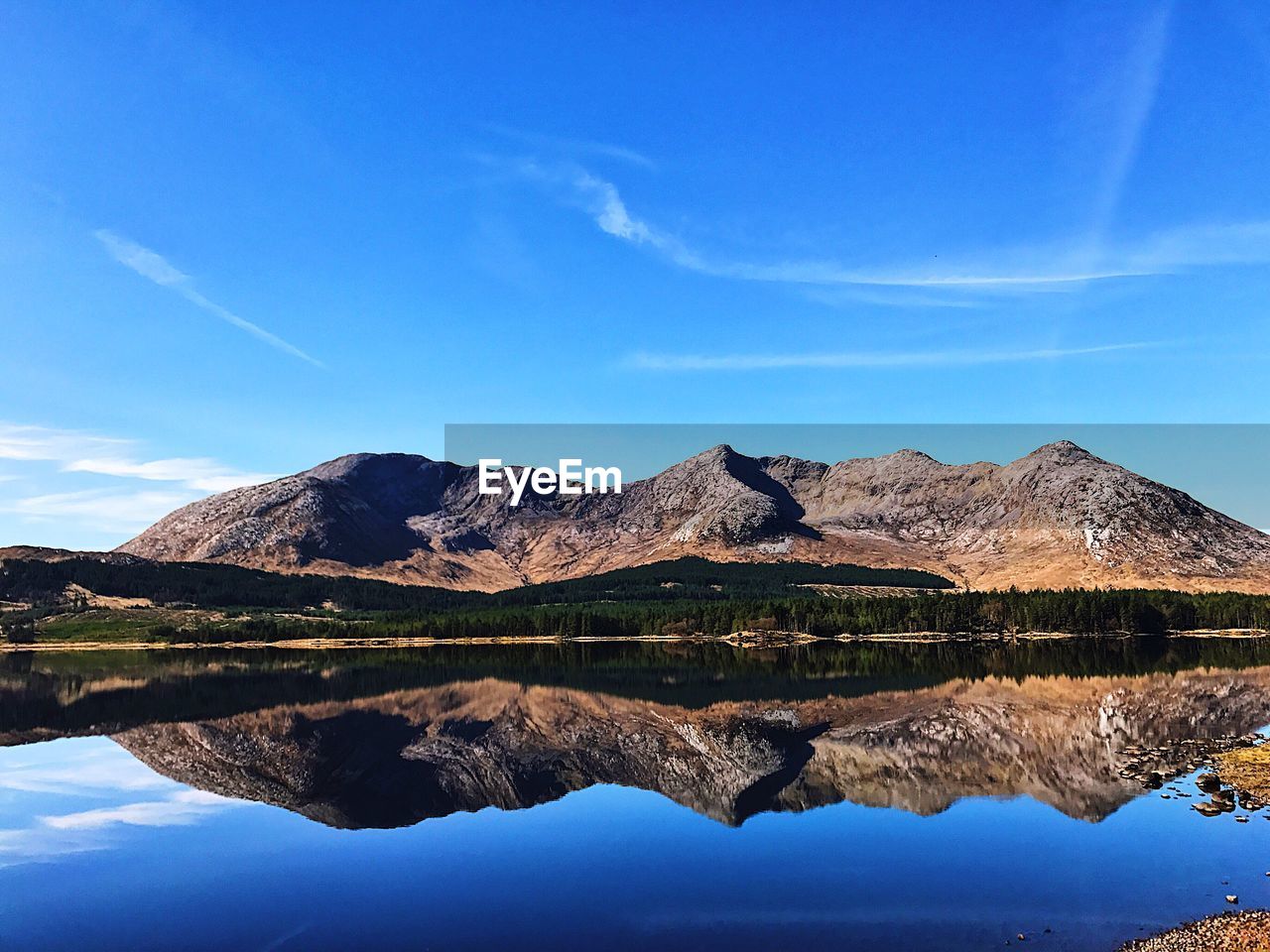 Scenic view of lake and mountains against blue sky