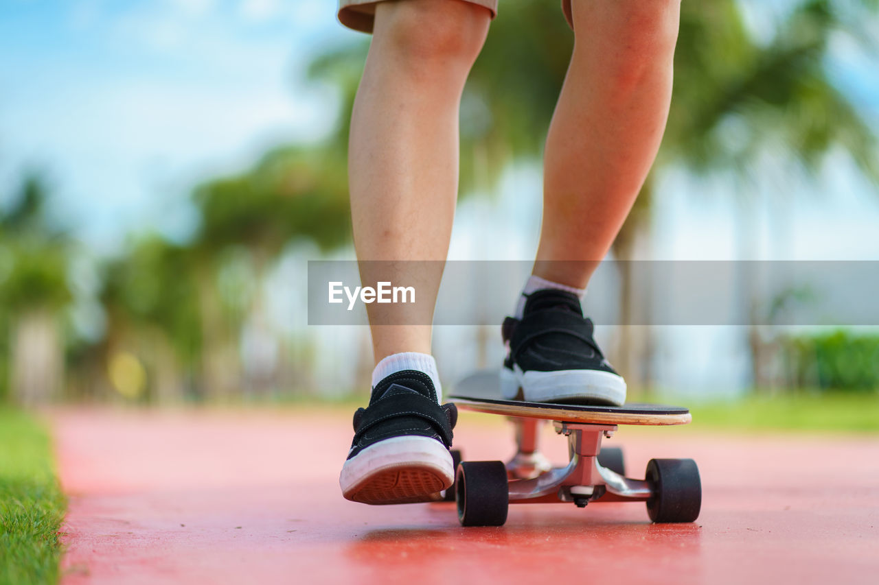 Low section of person skateboarding on land