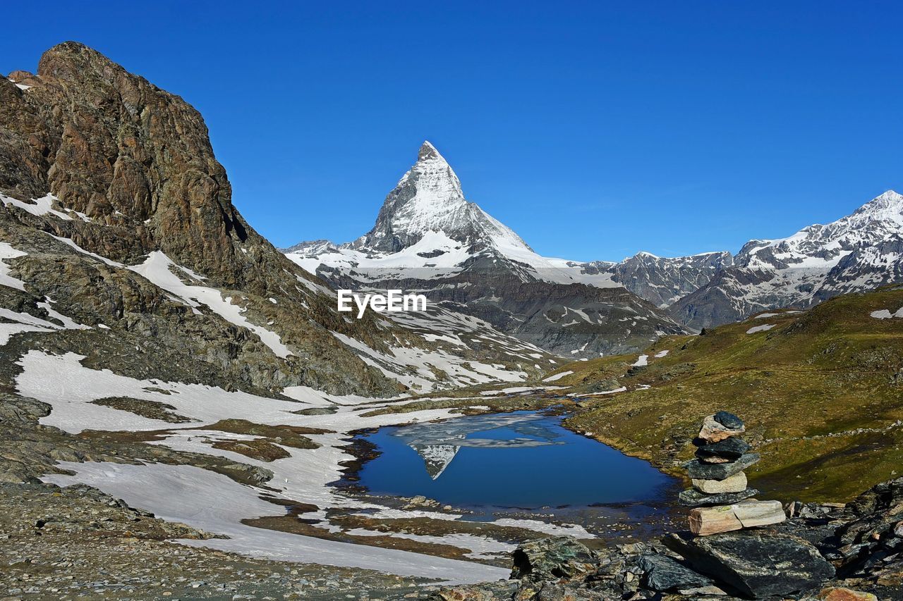 Scenic view of snowcapped mountains against clear blue sky