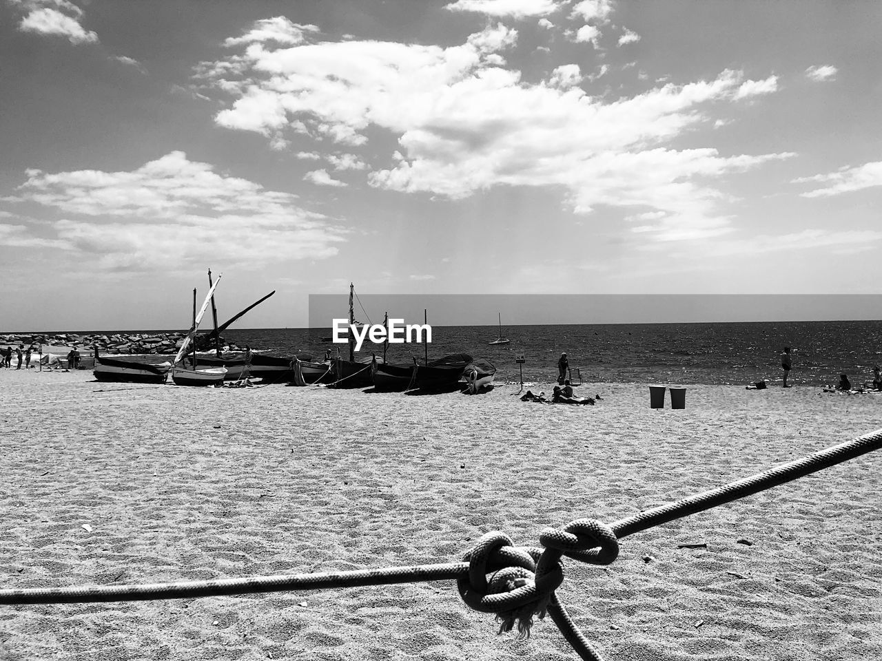 water, sky, sea, black and white, nature, cloud, nautical vessel, monochrome photography, beach, transportation, monochrome, land, day, horizon, scenics - nature, outdoors, horizon over water, mode of transportation, beauty in nature, rope, pier, travel, sunlight, tranquility, buoy, architecture, vehicle, travel destinations, shore, tranquil scene, no people, fishing