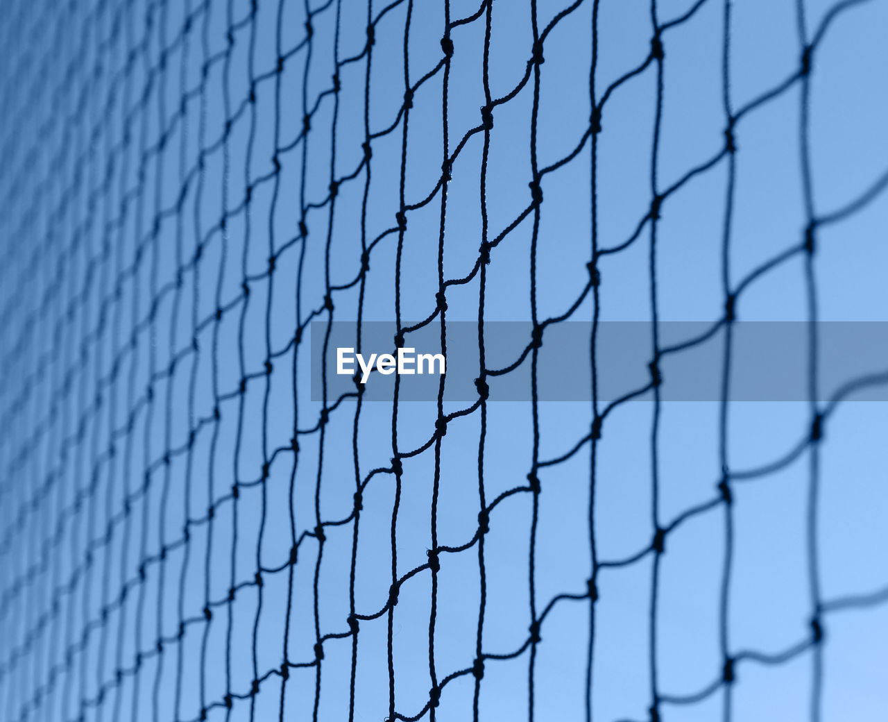 Close-up of fence against blue sky