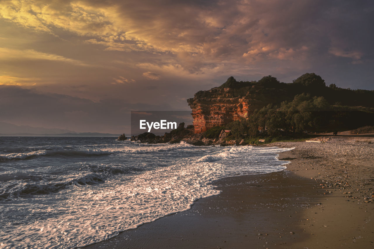 SCENIC VIEW OF BEACH AGAINST SKY AT SUNSET