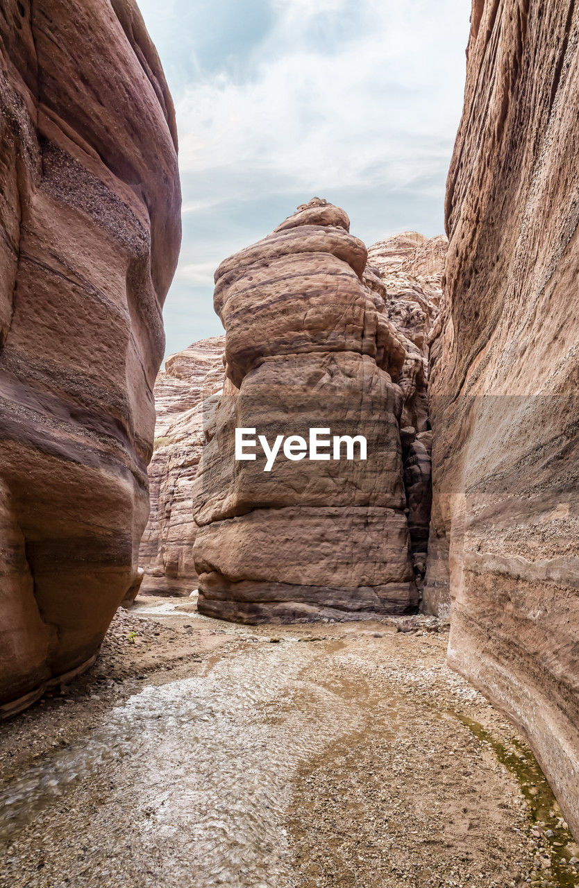 rock, arch, rock formation, nature, scenics - nature, landscape, travel destinations, cloud, sky, geology, non-urban scene, beauty in nature, environment, land, travel, no people, ancient history, tranquility, eroded, architecture, physical geography, desert, sandstone, wadi, outdoors, day, canyon, climate, tranquil scene, extreme terrain, tourism, terrain, cliff, valley, remote, arid climate, formation, idyllic
