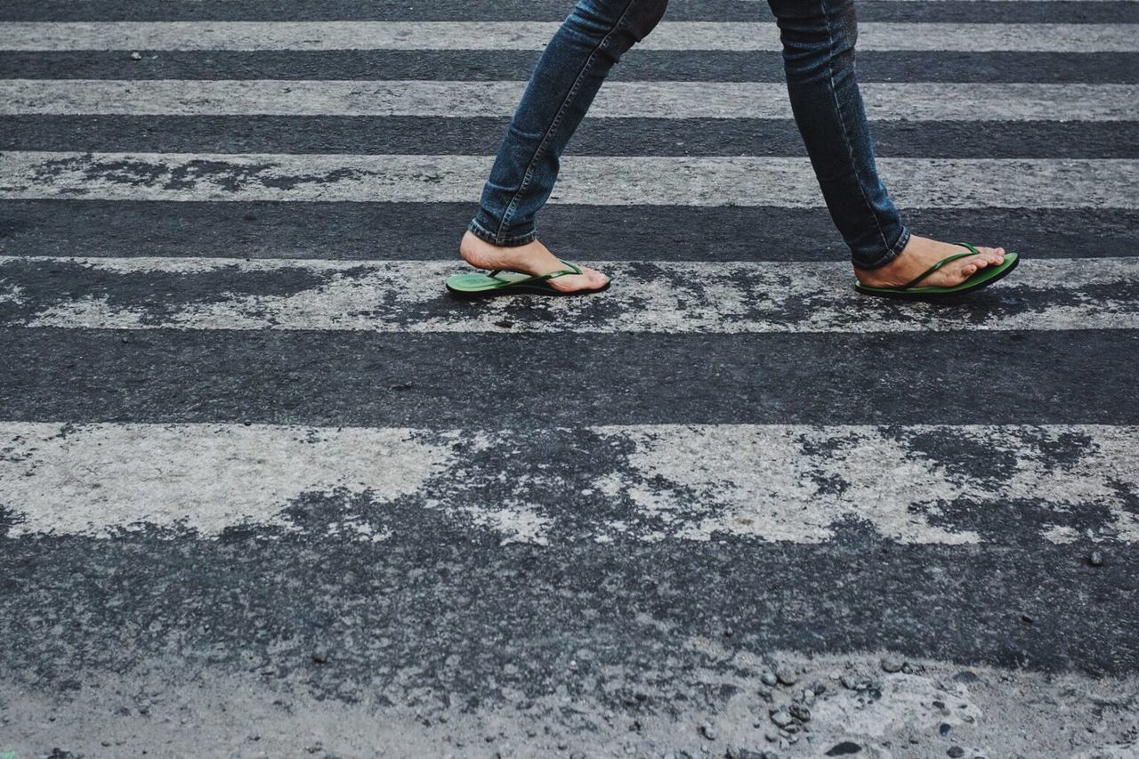 Low section of person walking on road