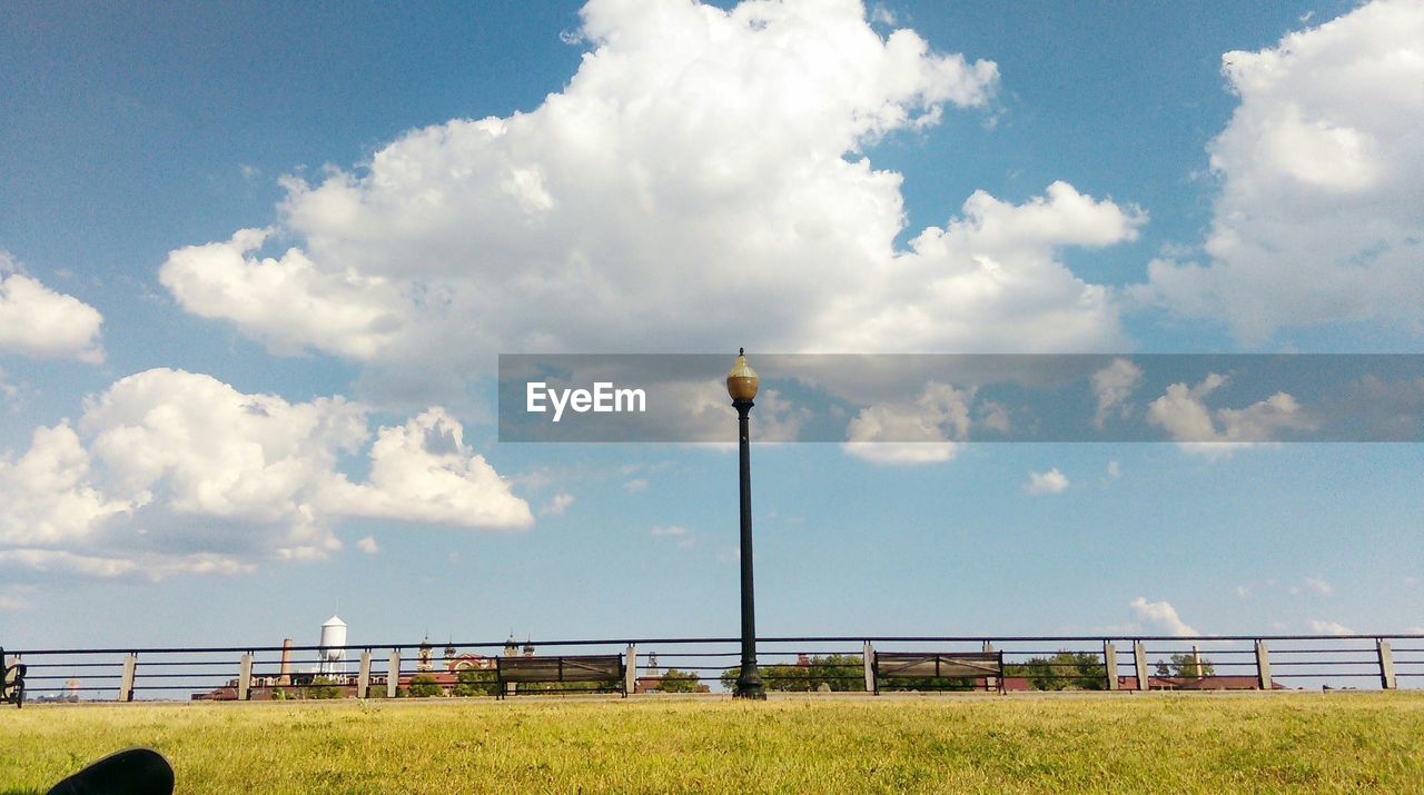 Street light on grassy field against sky