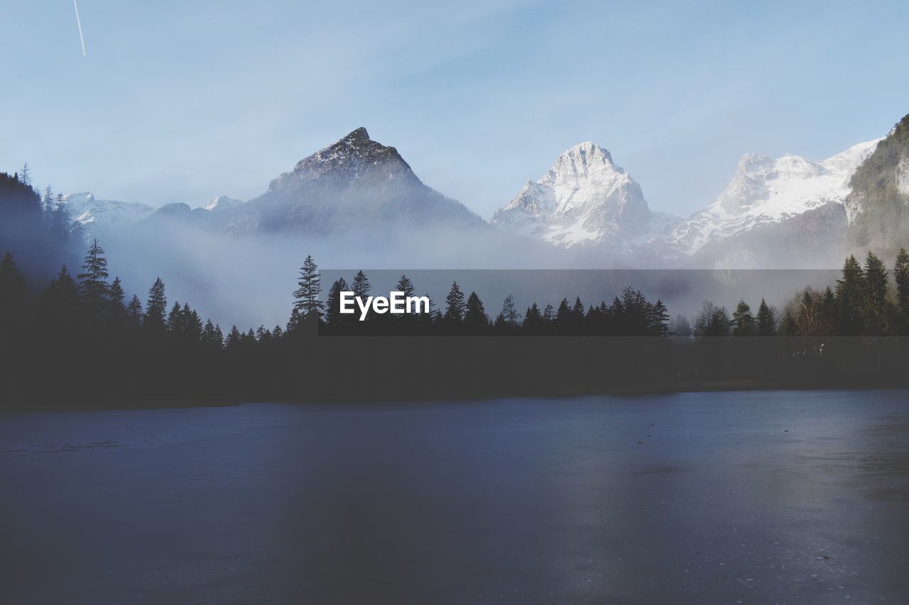 Scenic view of lake and mountains against sky during winter