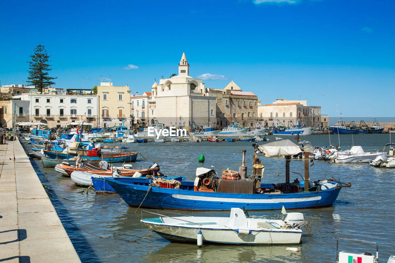 BOATS MOORED IN CANAL WITH BUILDINGS IN BACKGROUND