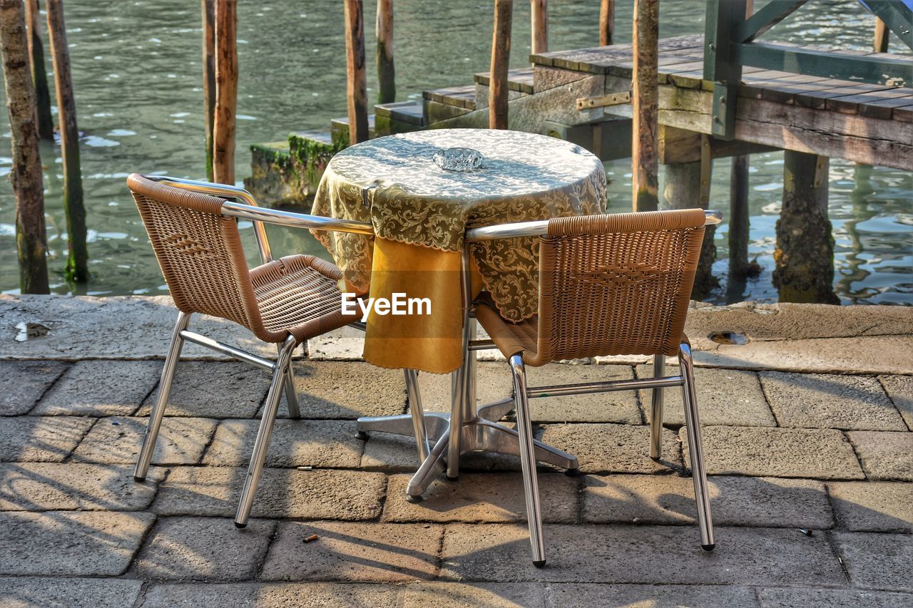 EMPTY CHAIRS AND TABLES IN WATER