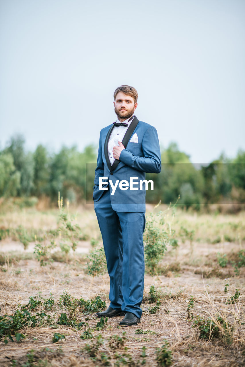 Portrait of young man standing on field